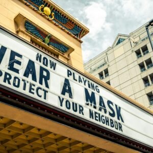 A vintage theater sign advises to wear a mask and protect your neighbor during COVID-19.